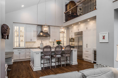 Large traditional open plan kitchen in Baltimore with white cabinets, granite worktops, white splashback, marble splashback, stainless steel appliances, dark hardwood flooring, an island, a submerged sink and shaker cabinets.