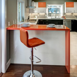 Idee per una cucina minimal di medie dimensioni con lavello sottopiano, ante lisce, ante arancioni, top in quarzo composito, paraspruzzi grigio, paraspruzzi in gres porcellanato, elettrodomestici in acciaio inossidabile, pavimento in gres porcellanato, penisola e top arancione