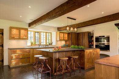 他の地域にある高級な広いカントリー風のおしゃれなキッチン (ダブルシンク、フラットパネル扉のキャビネット、茶色いキャビネット、グレーの床) の写真