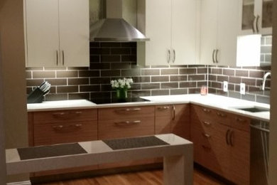 Photo of a small contemporary l-shaped kitchen in Boston with flat-panel cabinets and composite countertops.