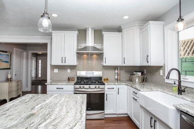 Mid-sized l-shaped medium tone wood floor and brown floor eat-in kitchen photo in Boston with a farmhouse sink, recessed-panel cabinets, white cabinets, granite countertops, gray backsplash, mosaic tile backsplash, stainless steel appliances, an island and gray countertops