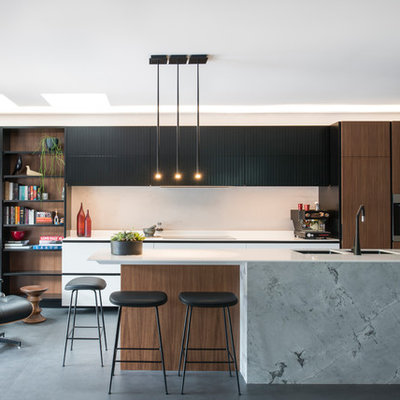 Example of a large trendy l-shaped porcelain tile and black floor open concept kitchen design in Sydney with a double-bowl sink, flat-panel cabinets, solid surface countertops, gray backsplash, stainless steel appliances, an island, white countertops and dark wood cabinets