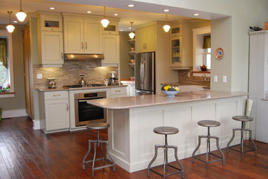 Eat-in kitchen - traditional l-shaped eat-in kitchen idea in Ottawa with a farmhouse sink, flat-panel cabinets, gray cabinets, quartz countertops, gray backsplash and stainless steel appliances