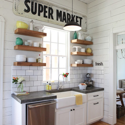 Mid-sized country medium tone wood floor kitchen photo in Austin with a farmhouse sink, concrete countertops, white backsplash, subway tile backsplash, stainless steel appliances, white cabinets and open cabinets