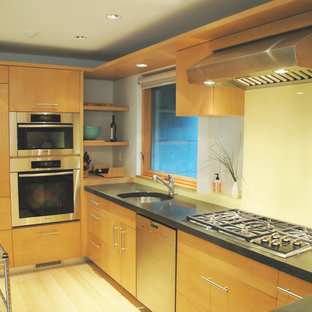 Photo of a mid-sized midcentury u-shaped open plan kitchen in Other with an undermount sink, flat-panel cabinets, medium wood cabinets, concrete benchtops, yellow splashback, glass sheet splashback, stainless steel appliances and light hardwood floors.