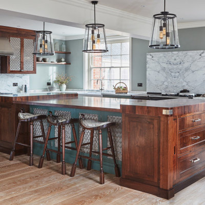 Eat-in kitchen - large traditional u-shaped medium tone wood floor and brown floor eat-in kitchen idea in Other with a farmhouse sink, marble countertops, marble backsplash, stainless steel appliances, an island, white countertops, recessed-panel cabinets, green cabinets and white backsplash