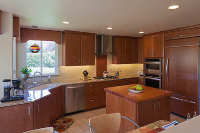 Example of a classic eat-in kitchen design in San Luis Obispo with medium tone wood cabinets, marble countertops, multicolored backsplash and an island