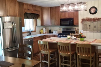 Traditional l-shaped kitchen/diner in Other with a double-bowl sink, shaker cabinets, composite countertops, stainless steel appliances and an island.