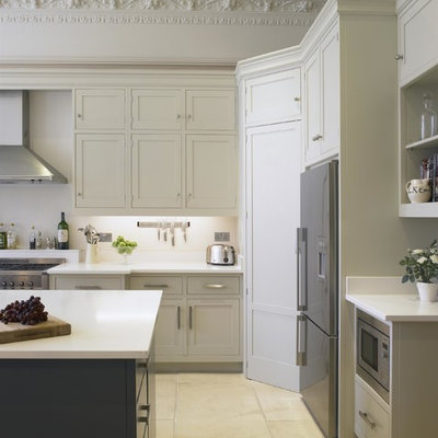 Large transitional kitchen photo in London with shaker cabinets, white cabinets, quartz countertops, white backsplash, an island and stainless steel appliances
