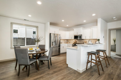 Inspiration for a mid-sized u-shaped laminate floor and brown floor open concept kitchen remodel in Other with brown backsplash, subway tile backsplash, white countertops and quartz countertops