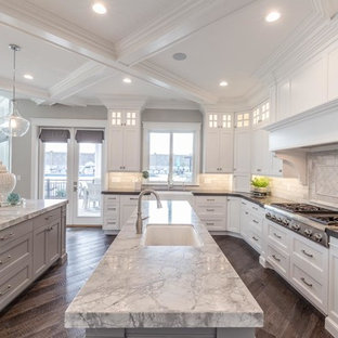 Large transitional open concept kitchen inspiration - Example of a large transitional u-shaped medium tone wood floor and brown floor open concept kitchen design in Salt Lake City with an undermount sink, recessed-panel cabinets, white cabinets, marble countertops, white backsplash, subway tile backsplash, stainless steel appliances and two islands