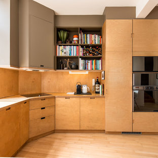 This is an example of a small contemporary open plan kitchen in London with flat-panel cabinets, light wood cabinets, wood worktops, beige splashback, wood splashback, light hardwood flooring, no island, beige floors and beige worktops.