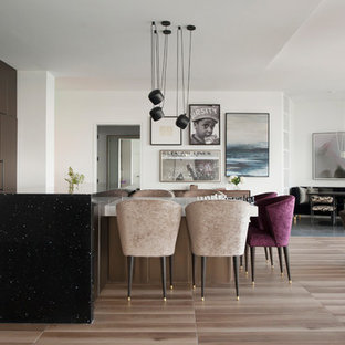 Contemporary open concept kitchen designs - Open concept kitchen - contemporary single-wall brown floor open concept kitchen idea in Los Angeles with an undermount sink, flat-panel cabinets, brown cabinets, black backsplash, paneled appliances, an island and white countertops