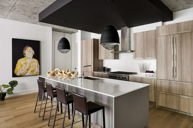 Large urban single-wall open concept kitchen photo in Chicago with flat-panel cabinets, quartz countertops, white backsplash, an island and white countertops