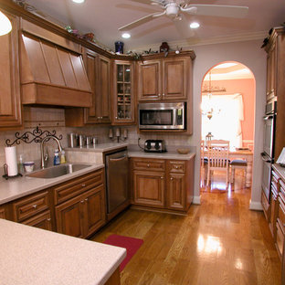 Eat-in kitchen - mid-sized contemporary u-shaped medium tone wood floor eat-in kitchen idea in Charlotte with a single-bowl sink, medium tone wood cabinets, beige backsplash, ceramic backsplash, stainless steel appliances and a peninsula