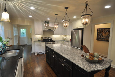 Inspiration for a large u-shaped kitchen pantry in Raleigh with a double-bowl sink, white cabinets, stainless steel appliances, dark hardwood flooring and an island.