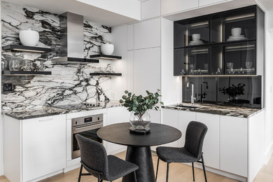 Example of a small trendy l-shaped light wood floor and brown floor eat-in kitchen design in Toronto with an undermount sink, flat-panel cabinets, white cabinets, quartzite countertops, multicolored backsplash, stone slab backsplash, paneled appliances, no island and multicolored countertops