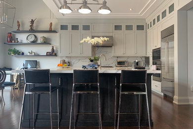 Eat-in kitchen - mid-sized transitional l-shaped medium tone wood floor and brown floor eat-in kitchen idea in Toronto with an undermount sink, shaker cabinets, white cabinets, quartz countertops, white backsplash, stone slab backsplash, stainless steel appliances, an island and white countertops