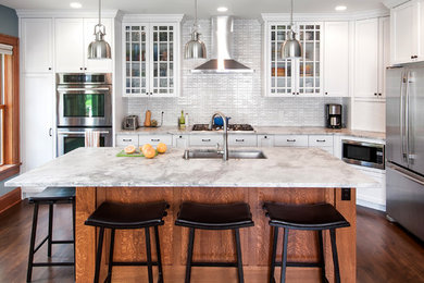 Inspiration for a mid-sized transitional l-shaped dark wood floor and brown floor open concept kitchen remodel in Minneapolis with an undermount sink, recessed-panel cabinets, white cabinets, quartzite countertops, white backsplash, stainless steel appliances, an island, glass tile backsplash and white countertops