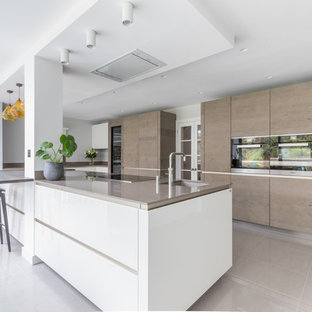 Large contemporary galley open plan kitchen in Sussex with flat-panel cabinets and an island.