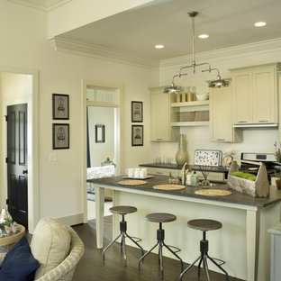 Traditional galley open plan kitchen in Other with recessed-panel cabinets, beige cabinets, concrete benchtops, white splashback, dark hardwood floors and with island.