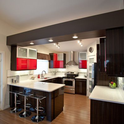 Example of a trendy u-shaped kitchen design in Calgary with red cabinets, flat-panel cabinets and stainless steel appliances
