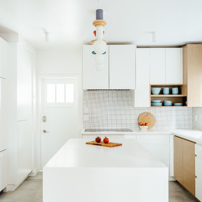 Inspiration for a mid-sized scandinavian l-shaped gray floor and concrete floor kitchen remodel in Salt Lake City with flat-panel cabinets, white cabinets, white backsplash, an island, white countertops, a single-bowl sink, mosaic tile backsplash and paneled appliances
