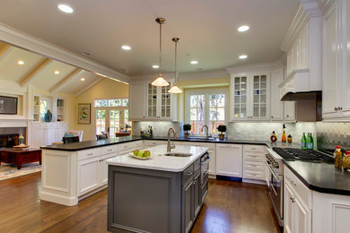 Elegant kitchen photo in San Francisco with glass-front cabinets, stainless steel appliances and subway tile backsplash
