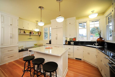 Example of a large minimalist l-shaped enclosed kitchen design in San Francisco with shaker cabinets, white cabinets, granite countertops, stainless steel appliances and an island