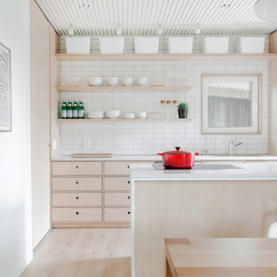 Small danish galley light wood floor and beige floor open concept kitchen photo in Calgary with an undermount sink, flat-panel cabinets, light wood cabinets, quartz countertops, white backsplash, ceramic backsplash, stainless steel appliances, an island and white countertops