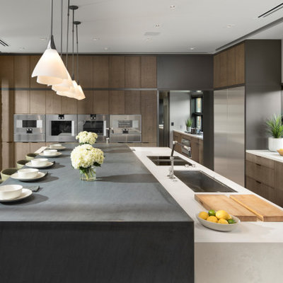 Huge trendy l-shaped porcelain tile and gray floor open concept kitchen photo in Las Vegas with an undermount sink, flat-panel cabinets, quartz countertops, stainless steel appliances, an island, white countertops, medium tone wood cabinets and window backsplash