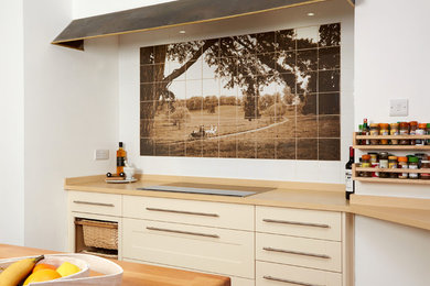 Cette photo montre une cuisine nature avec des portes de placard beiges, un plan de travail en bois, une crédence multicolore et une crédence en céramique.