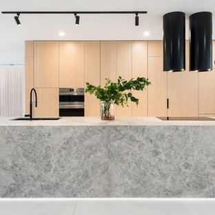 Mid-sized contemporary galley eat-in kitchen in Brisbane with an undermount sink, light wood cabinets, limestone benchtops, grey splashback, marble floors, with island, white floor, grey benchtop, flat-panel cabinets and stainless steel appliances.