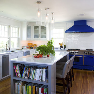 Kitchen - mid-sized coastal u-shaped medium tone wood floor and brown floor kitchen idea in Boston with glass-front cabinets, subway tile backsplash, colored appliances, an undermount sink, white cabinets, white backsplash and an island
