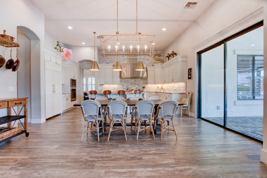 Eat-in kitchen - mid-sized transitional u-shaped medium tone wood floor and brown floor eat-in kitchen idea in Phoenix with shaker cabinets, white cabinets, gray backsplash, marble backsplash, stainless steel appliances, an island, a farmhouse sink and granite countertops