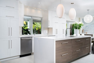 Large trendy kitchen photo in Miami with an undermount sink, flat-panel cabinets, white cabinets, quartz countertops, white backsplash, mosaic tile backsplash, stainless steel appliances and an island