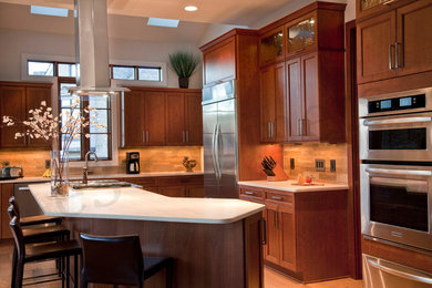 Eat-in kitchen - transitional l-shaped eat-in kitchen idea in Charlotte with an undermount sink, flat-panel cabinets, brown cabinets, quartz countertops, beige backsplash, stone tile backsplash and stainless steel appliances