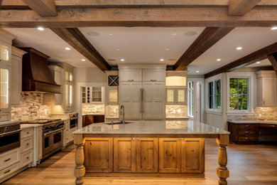 Example of a large classic u-shaped medium tone wood floor, brown floor and exposed beam eat-in kitchen design in Charlotte with an undermount sink, shaker cabinets, white cabinets, quartz countertops, beige backsplash, glass tile backsplash, paneled appliances, an island and beige countertops