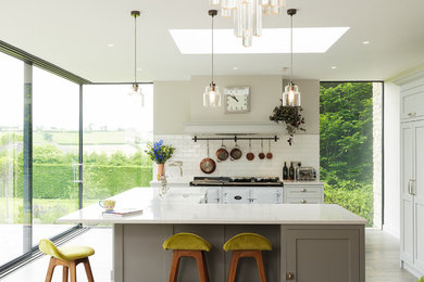 Inspiration for a large classic kitchen in Other with shaker cabinets, composite countertops, white splashback, metro tiled splashback, an island, grey cabinets and white appliances.