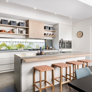Design ideas for a mid-sized contemporary galley kitchen in Perth with an undermount sink, flat-panel cabinets, white cabinets, mirror splashback, stainless steel appliances, with island, grey floor and grey benchtop.