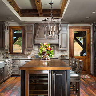 Esempio di una grande cucina stile rurale con lavello stile country, ante con bugna sagomata, ante con finitura invecchiata, paraspruzzi marrone, elettrodomestici da incasso, parquet scuro e top in rame