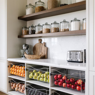 This is an example of a traditional kitchen pantry in Salt Lake City with beige cabinets, white splashback and white benchtop.