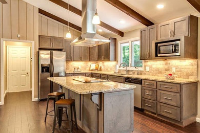 Example of a transitional dark wood floor and brown floor kitchen design in Other with an undermount sink, recessed-panel cabinets, medium tone wood cabinets, granite countertops, beige backsplash, travertine backsplash, stainless steel appliances and an island