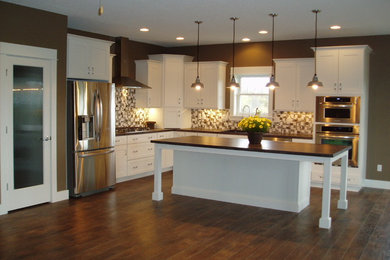 Example of a mid-sized eclectic kitchen design in Cedar Rapids with an island, shaker cabinets, white cabinets, glass tile backsplash, stainless steel appliances and a single-bowl sink