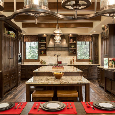 Eat-in kitchen - large rustic u-shaped dark wood floor eat-in kitchen idea in Calgary with a farmhouse sink, shaker cabinets, dark wood cabinets, granite countertops, beige backsplash, paneled appliances, an island and travertine backsplash