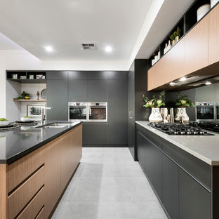 Design ideas for a mid-sized contemporary l-shaped open plan kitchen in Perth with an undermount sink, flat-panel cabinets, black cabinets, metallic splashback, mirror splashback, with island, grey floor, grey benchtop, solid surface benchtops, stainless steel appliances and ceramic floors.