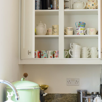 The white furniture provides a neutral backdrop for the clients colourful china