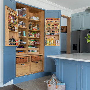 This is an example of a large beach style kitchen in Surrey with shaker cabinets, blue cabinets, quartzite benchtops, stainless steel appliances, ceramic floors, with island, white benchtop and grey floor.