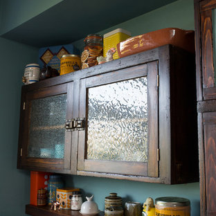 Mid-sized eclectic single-wall open plan kitchen in Other with a farmhouse sink, flat-panel cabinets, distressed cabinets, solid surface benchtops, blue splashback, ceramic splashback, stainless steel appliances, porcelain floors, with island and multi-coloured floor.