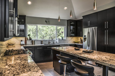 Eat-in kitchen - large transitional u-shaped porcelain tile and brown floor eat-in kitchen idea in Houston with an undermount sink, flat-panel cabinets, black cabinets, granite countertops, gray backsplash, marble backsplash, stainless steel appliances and an island